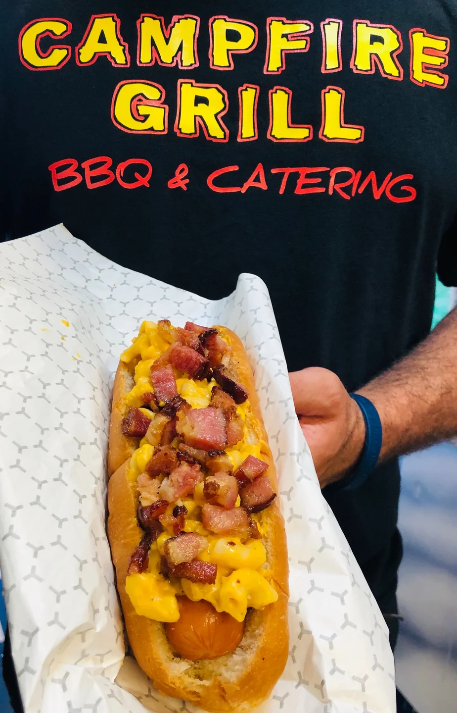 Hot dog loaded with mac and cheese and bacon bits