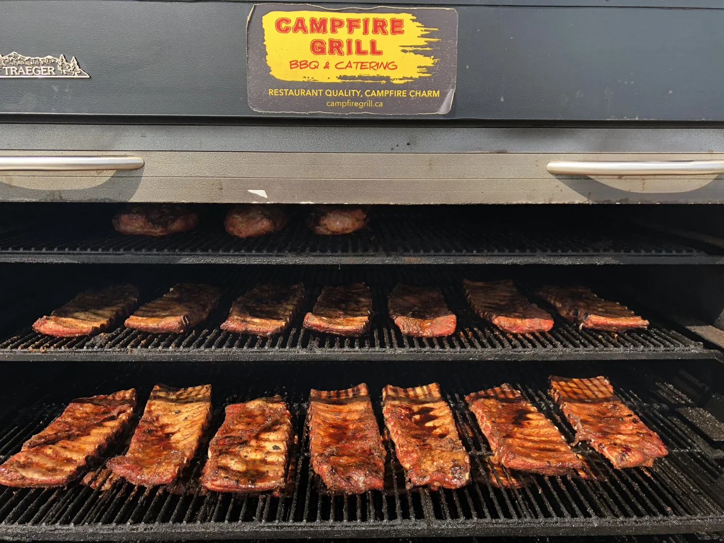 Racks of ribs slow-smoking on the Campfire Grill Traeger