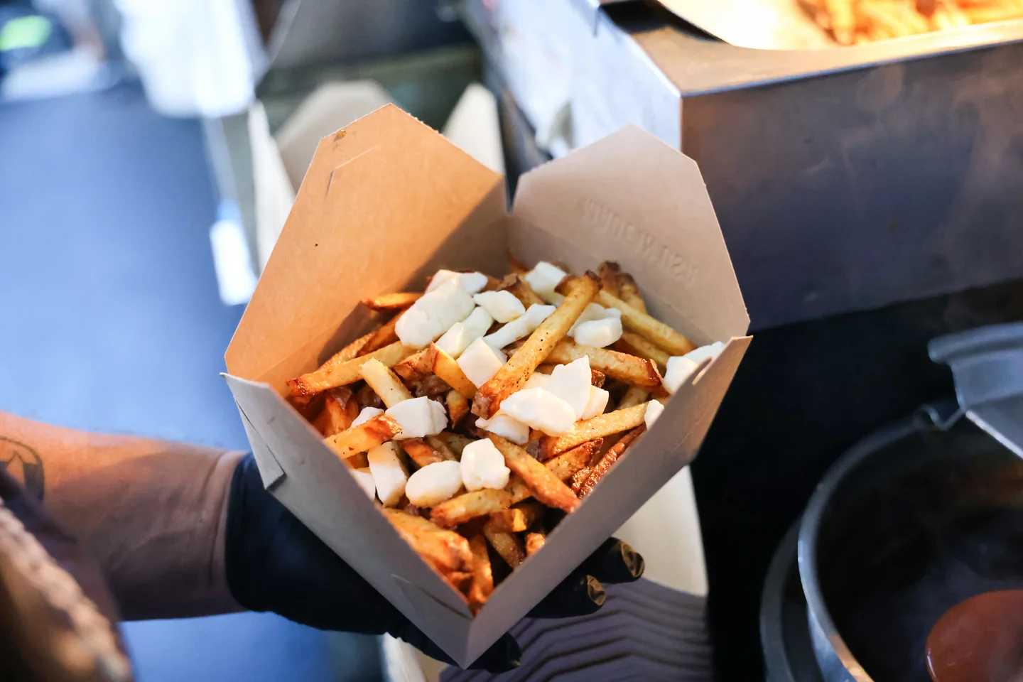 Fresh-cut fries topped with cheese curds in a kraft box