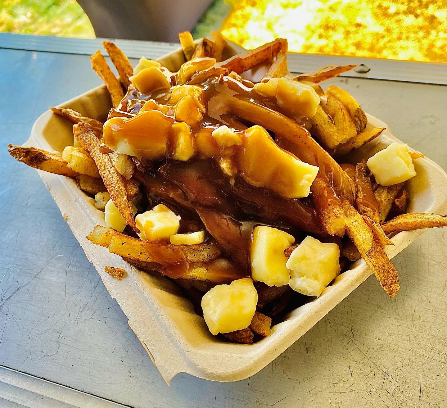 Classic poutine — fries, brown gravy, and cheese curds in an eco box